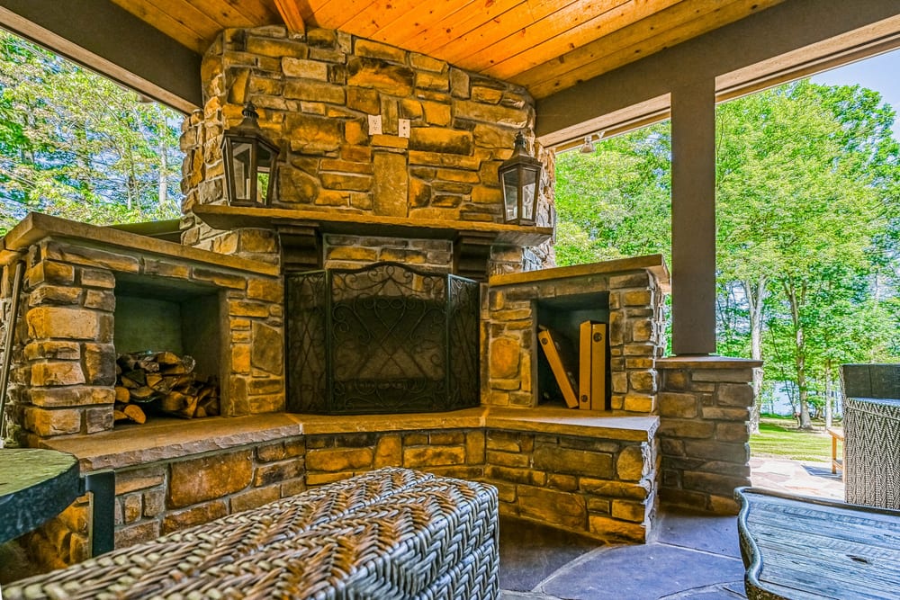 Covered stone fireplace patio at a Deep Creek lodge