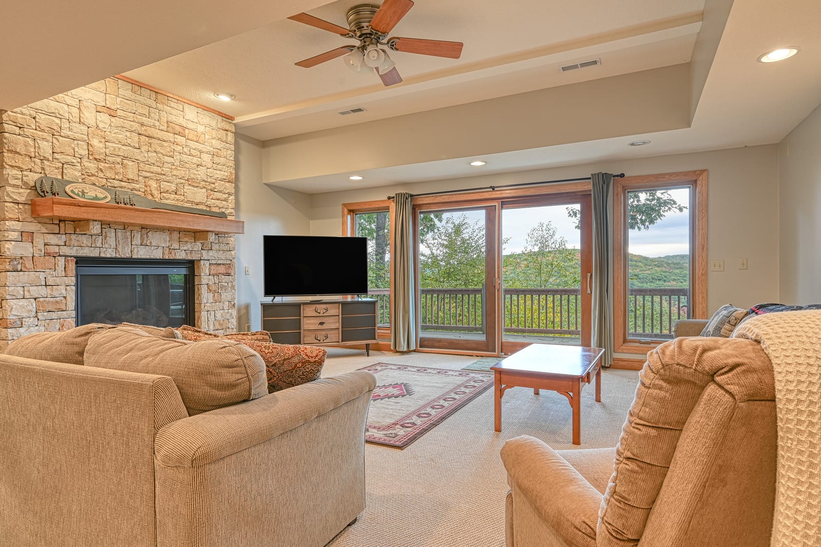 Warm great room with a stone fireplace in a Deep Creek lodge